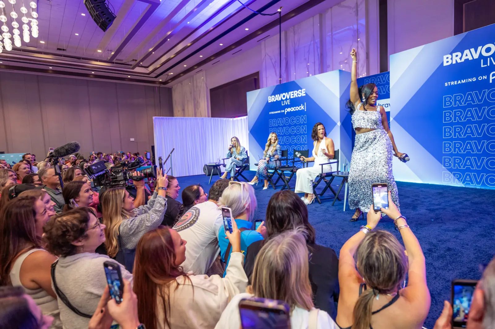 Fans with phones raised during a panel at BravoCon 2025