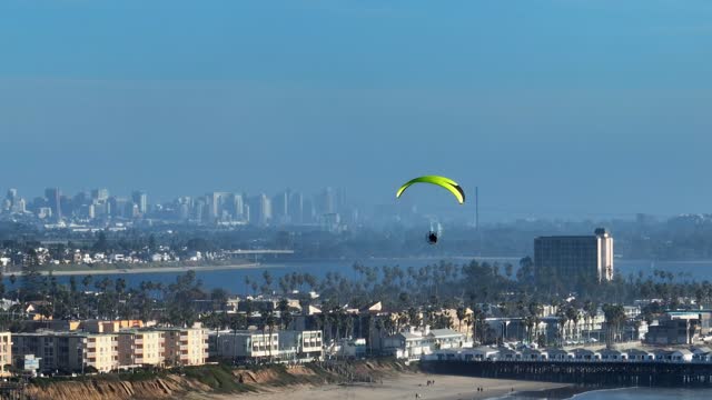 Paramotor Paraglider flying off the coastline of Pacific Beach and Crystal Pier in San Diego California | Drone Video – 1